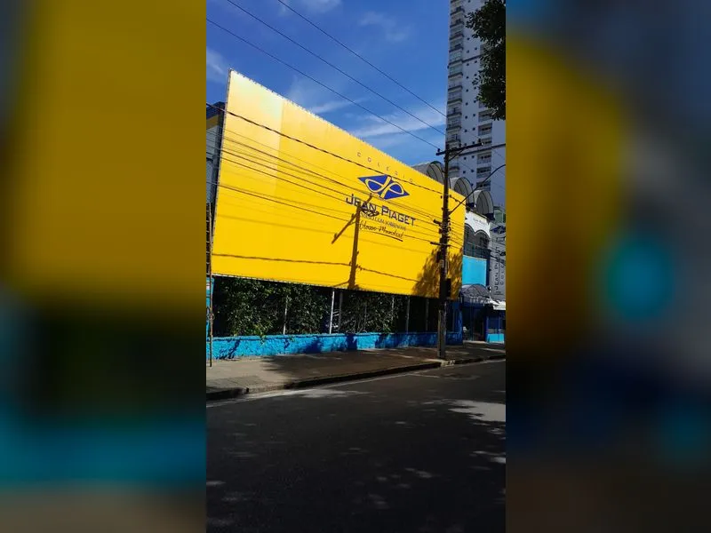 Lona de toldo amarela com adesivo recortado aplicado na fachada do Colégio Jean Piaget — Cromatica Comunicação Visual, Santos/SP