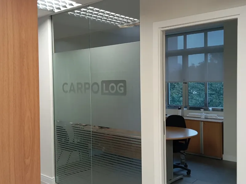 Adesivo jateado recortado com a marca da transportadora Carpo Logistics em divisória de vidro — Cromatica Comunicação Visual, Santos/SP