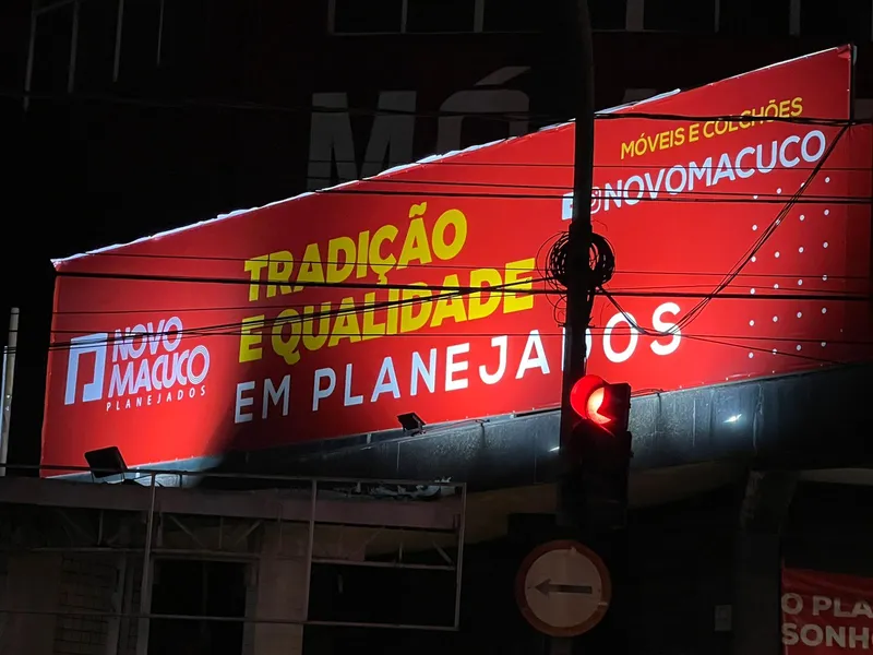 Painel de lona com reforço e ilhós na fachada da Novo Macuco Móveis — Cromatica Comunicação Visual, Santos/SP