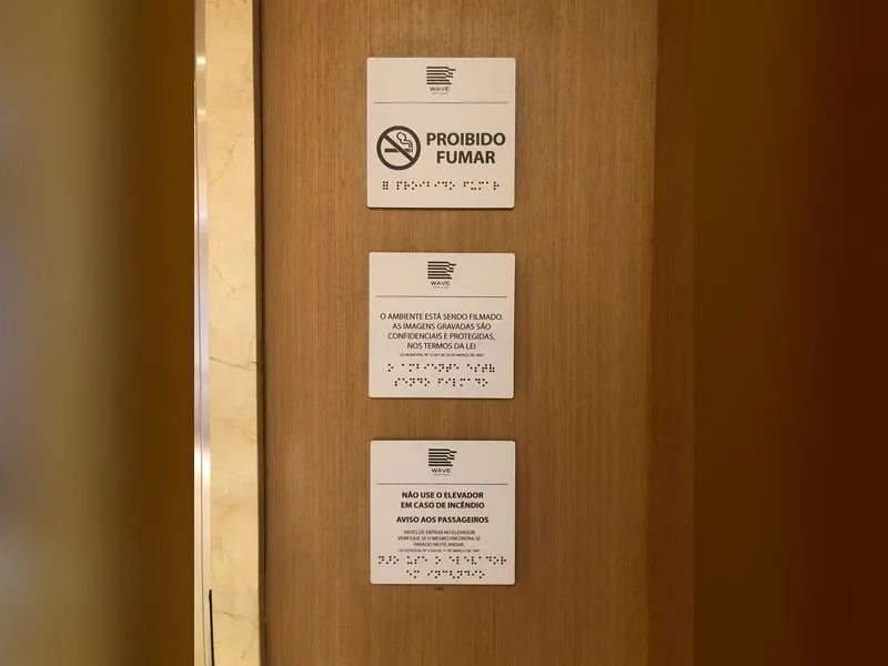Placas de sinalização com braille em ACM e impressão UV no prédio corporativo Wave Office — Cromatica Comunicação Visual, Santos/SP